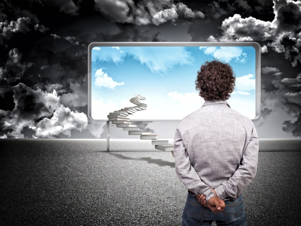 A person standing with their back to the camera, looking at a large frame displaying a bright sky with clouds, alongside a staircase leading upwards within the frame.