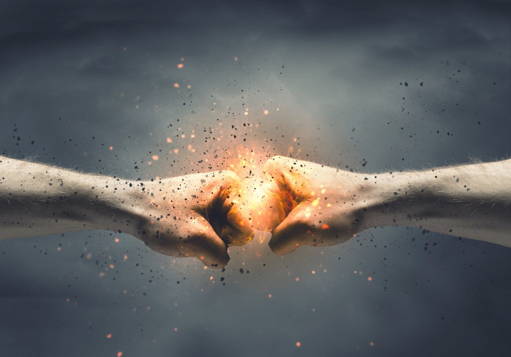 Two fists colliding with a burst of light and particles, symbolizing power and energy.